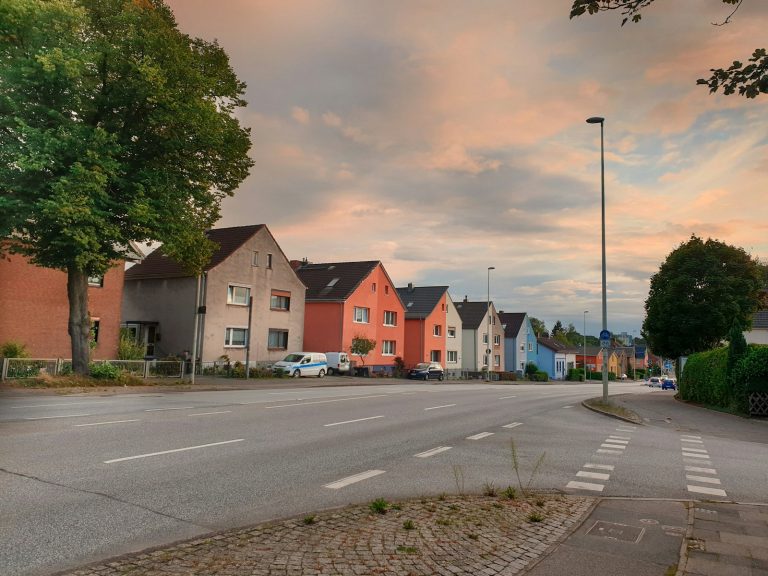 cars parked beside road near houses during daytime